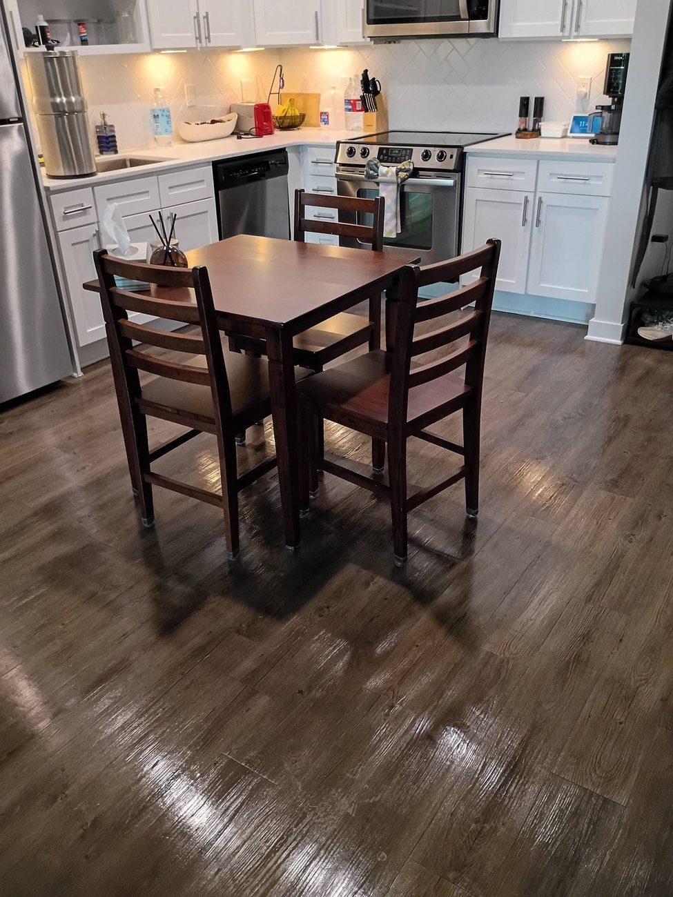 A clean kitchen and dining area with polished wood floors