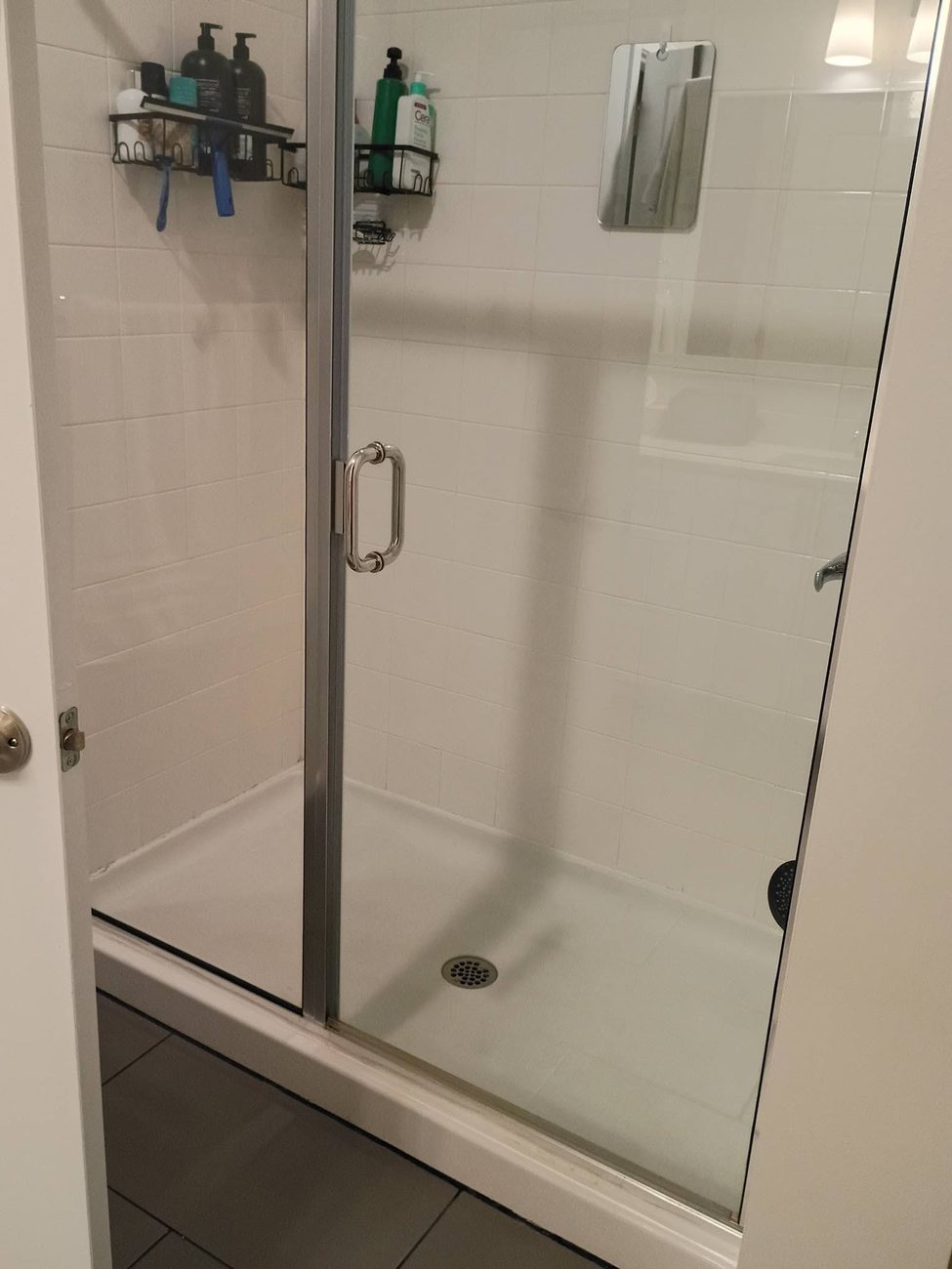 A glass shower screen cleaned until it is completely clear